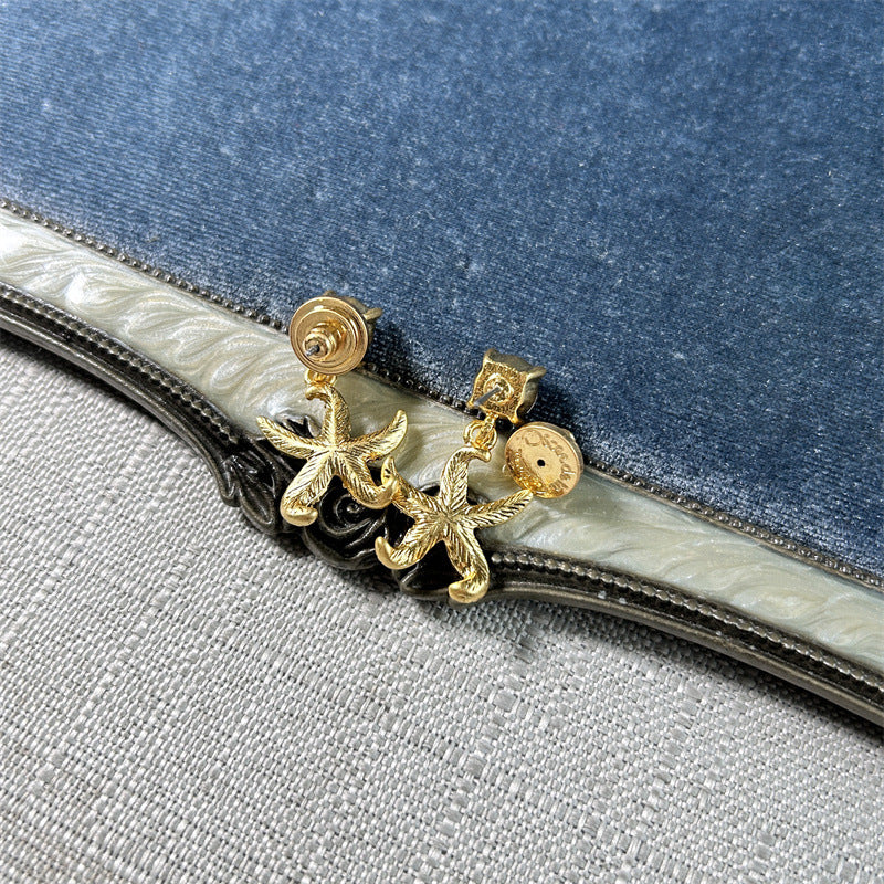 Gold starfish charm studs with circular back caps