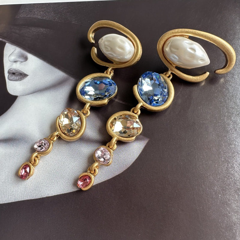 Long crystal drop earrings in gold with blue stones and small pink and clear crystals