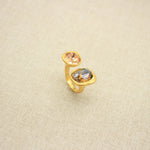 Adjustable open band gemstone ring with peach oval top stone and warm gold oval bottom