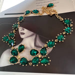 Gold-tone link crystal necklace with green emerald-cut teardrop and round stones