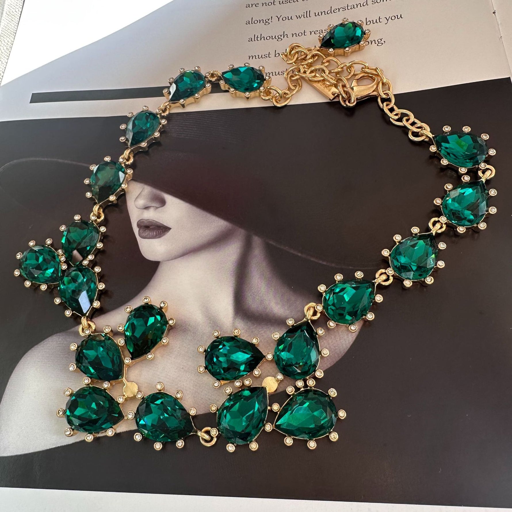 Gold-tone link crystal necklace with green emerald-cut teardrop and round stones