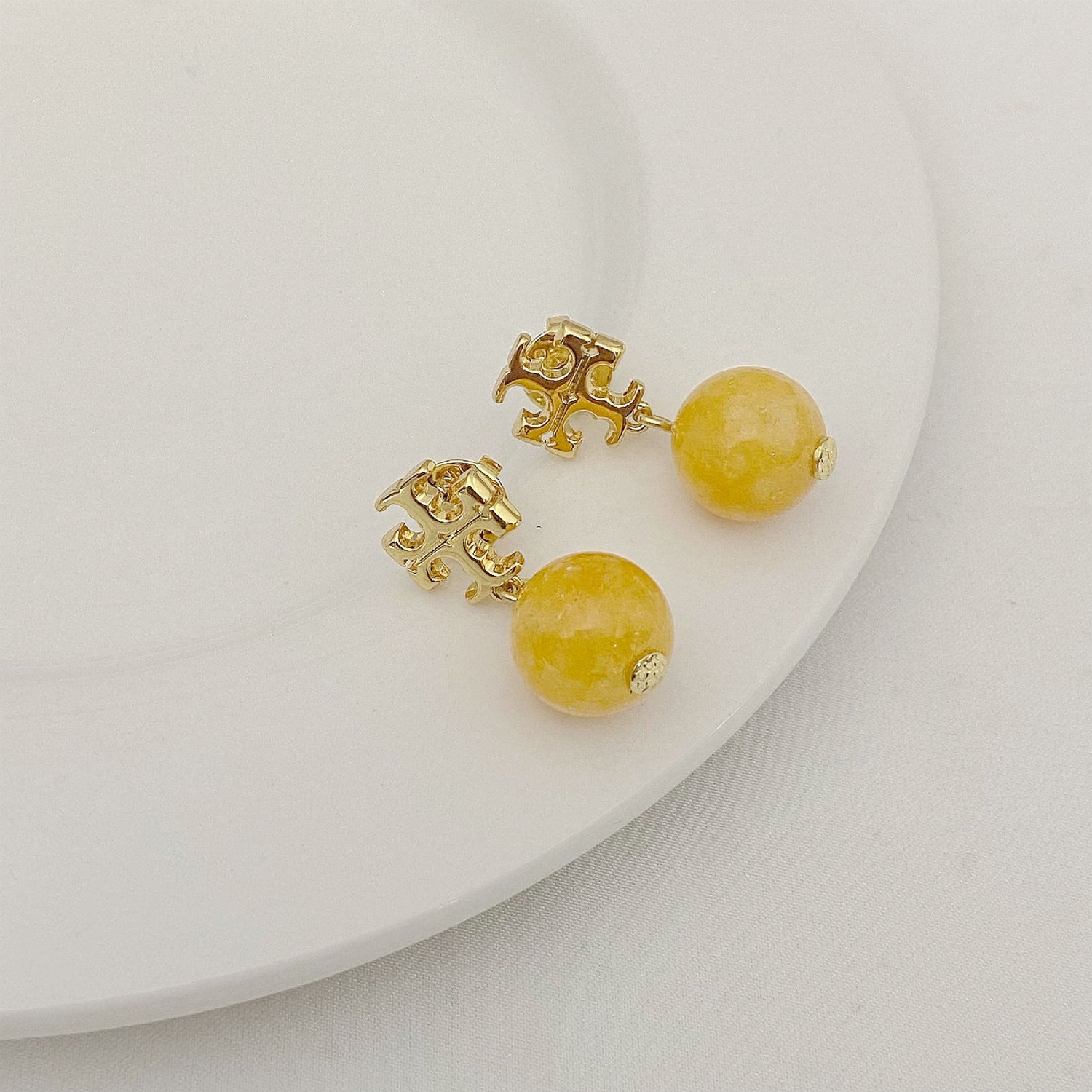 Gold openwork logo pendant earrings with yellow agate-style beads