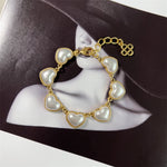 White pearl heart bracelet, gold-tone chain with heart charms