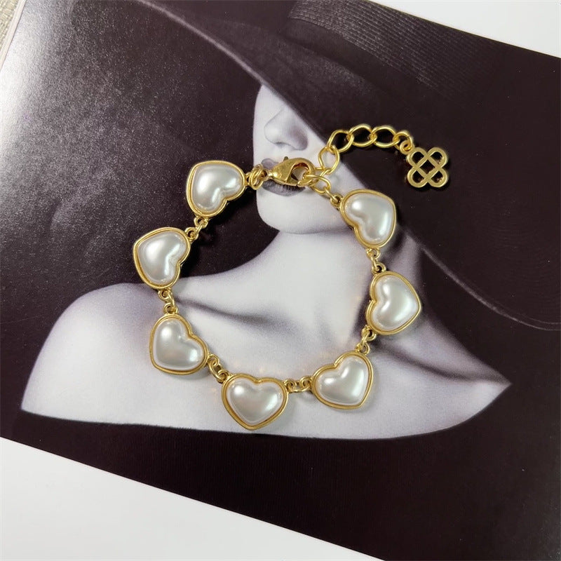 White pearl heart bracelet, gold-tone chain with heart charms