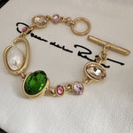 O-ring crystal pearl bracelet, gold tone with green oval center stone, pink crystals, pearl