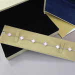 Gold tone bracelet with lavender clover charms on a delicate chain