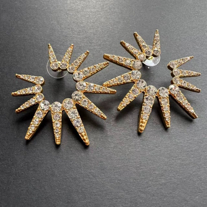 Gold starburst earrings with clear pavé stones and round stud backs
