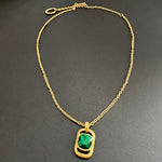 Gold-tone square pendant necklace with hammered texture and green faceted stone