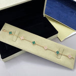 Goldfarbenes Armband mit Kleeblatt-Motiven in Grün, Gliederkette mit funkelnden Zwischenstücken