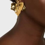 Close-up of gold-tone ivy leaf pearl earrings with round faux pearl