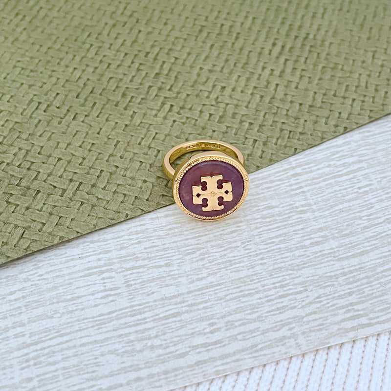 Round enamel metal ring with purple shell center and gold-tone bezel