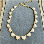 Heart-shaped necklace with gold chain and pearl white heart charms