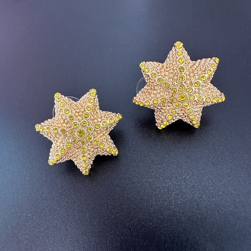 Oscar de la Renta gold-tone star stud earrings with yellow-green gem-like stones