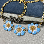 Enamel cherry blossom pendant necklace with blue flowers and gold chain with clear round stones