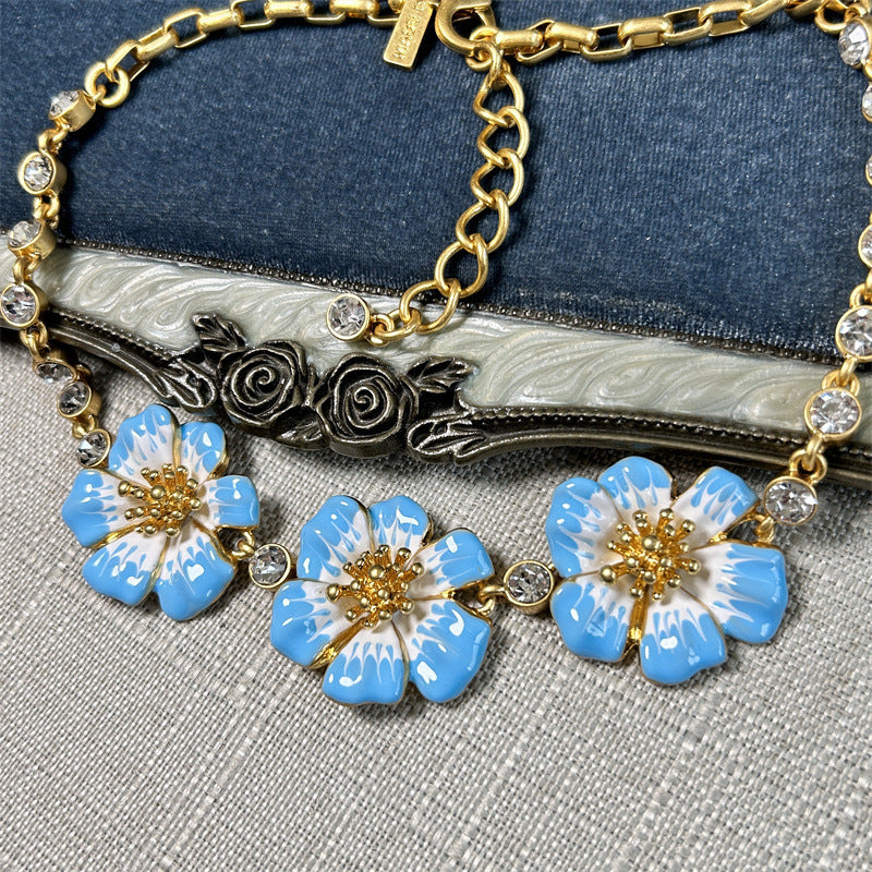 Enamel cherry blossom pendant necklace with blue flowers and gold chain with clear round stones