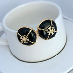 Schwarze Emaille-Stud-Ohrringe mit goldfarbenem Kreuz-Emblem, rundes Design