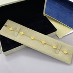Gold-tone clover bracelet with small four-leaf charm links and chain