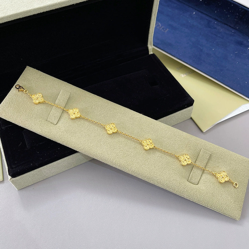 Gold-tone clover bracelet with small four-leaf charm links and chain