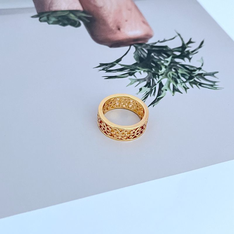 Gold openwork logo metal ring, rounded profile with repeating lattice cutouts