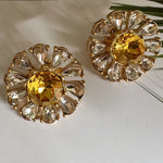 Sunburst flower stud earrings with golden-yellow round center and clear teardrop stones