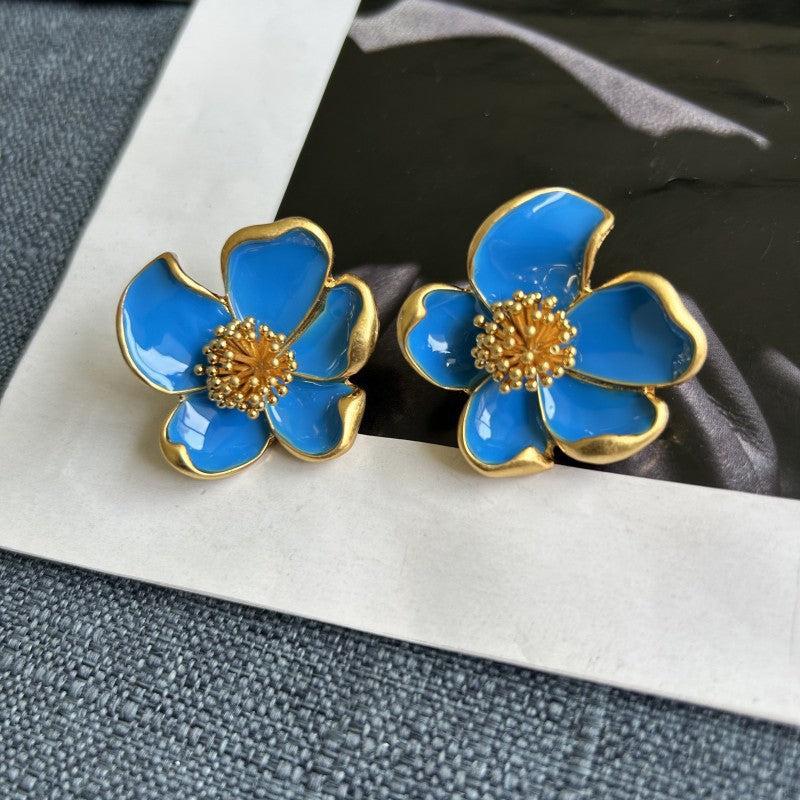 Lake blue enamel floral stud earrings with gold-tone edges and golden beaded center