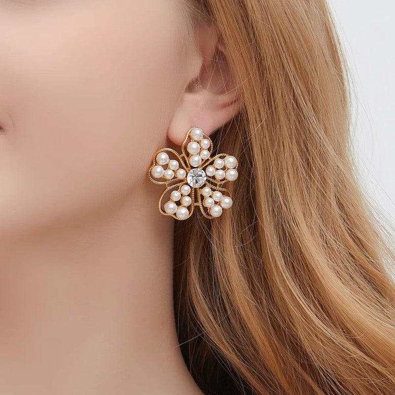 White pearl floral stud earrings with openwork petals and small pearl accents