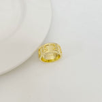 Gold letter band ring with patterned engraving on top and open side profile