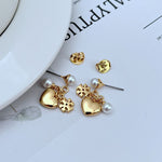 Gold-tone earrings: heart charms with rhinestone detail and dangling pearls