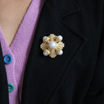 Gold-tone pearl and crystal brooch with central white pearl on scalloped rays