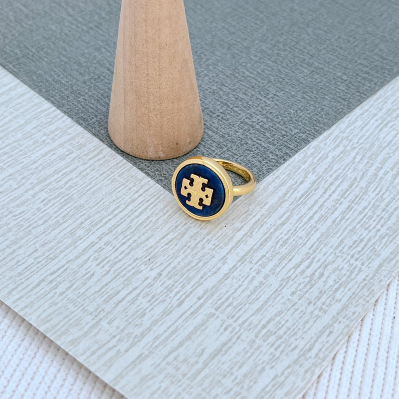 Round enamel metal ring with dark blue shell center and gold-tone bezel