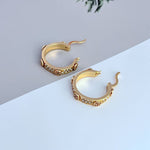 Gold hoop earrings with round logo charm and crystal pavé trim