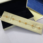 Clover bracelet in gold tone with red agate stones and four-leaf motifs