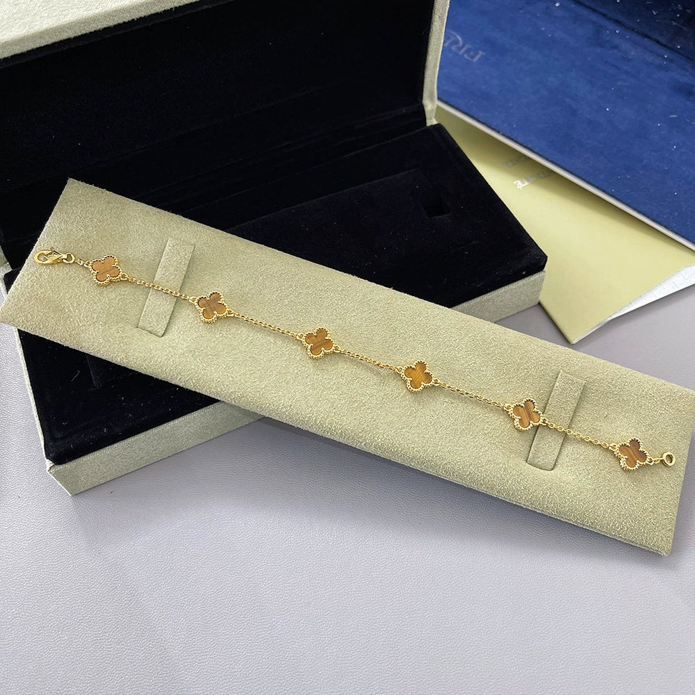 Clover bracelet in gold tone with red agate stones and four-leaf motifs