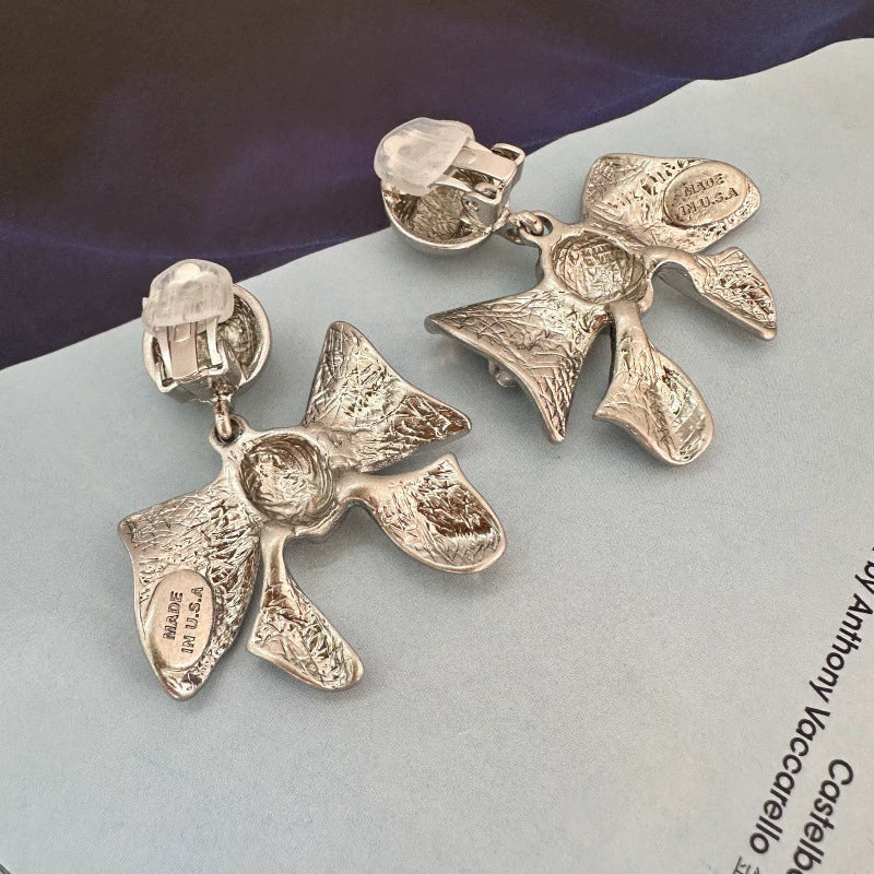 Silver-tone bow drop earrings with clip backs and textured ribbon bows