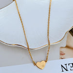 Gold-tone heart-shaped shell pendant necklace with engraved shell detail on the heart