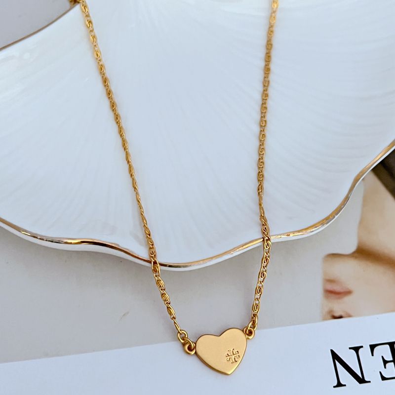 Gold heart pendant necklace on fine curb-link chain