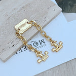 Gold chunky chain with rectangular engraved tag and two H-shaped link charms