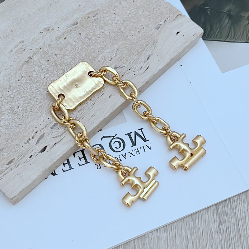 Gold chunky chain with rectangular engraved tag and two H-shaped link charms