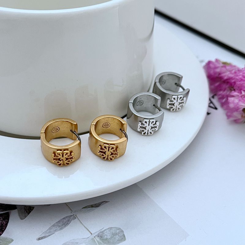 Matte gold and matte silver wide-band logo hoop earrings with circular emblem fronts