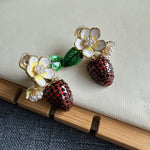 Enamel flower & strawberry clip-on earrings with green leaves, faux pearl clusters.