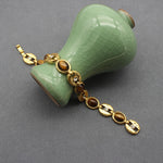 Gold-tone chain necklace with oval blue stones and round clasp accent links