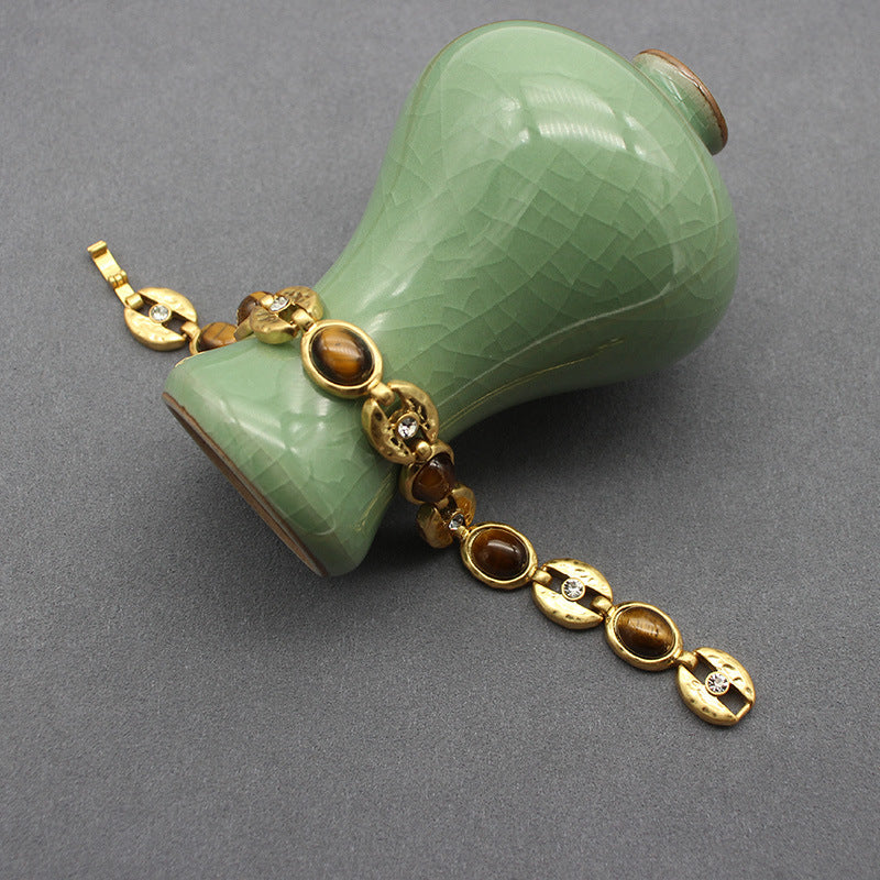 Gold-tone chain necklace with oval blue stones and round clasp accent links