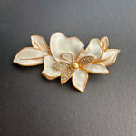 White enamel jasmine flower brooch with gold leaves and rhinestone center
