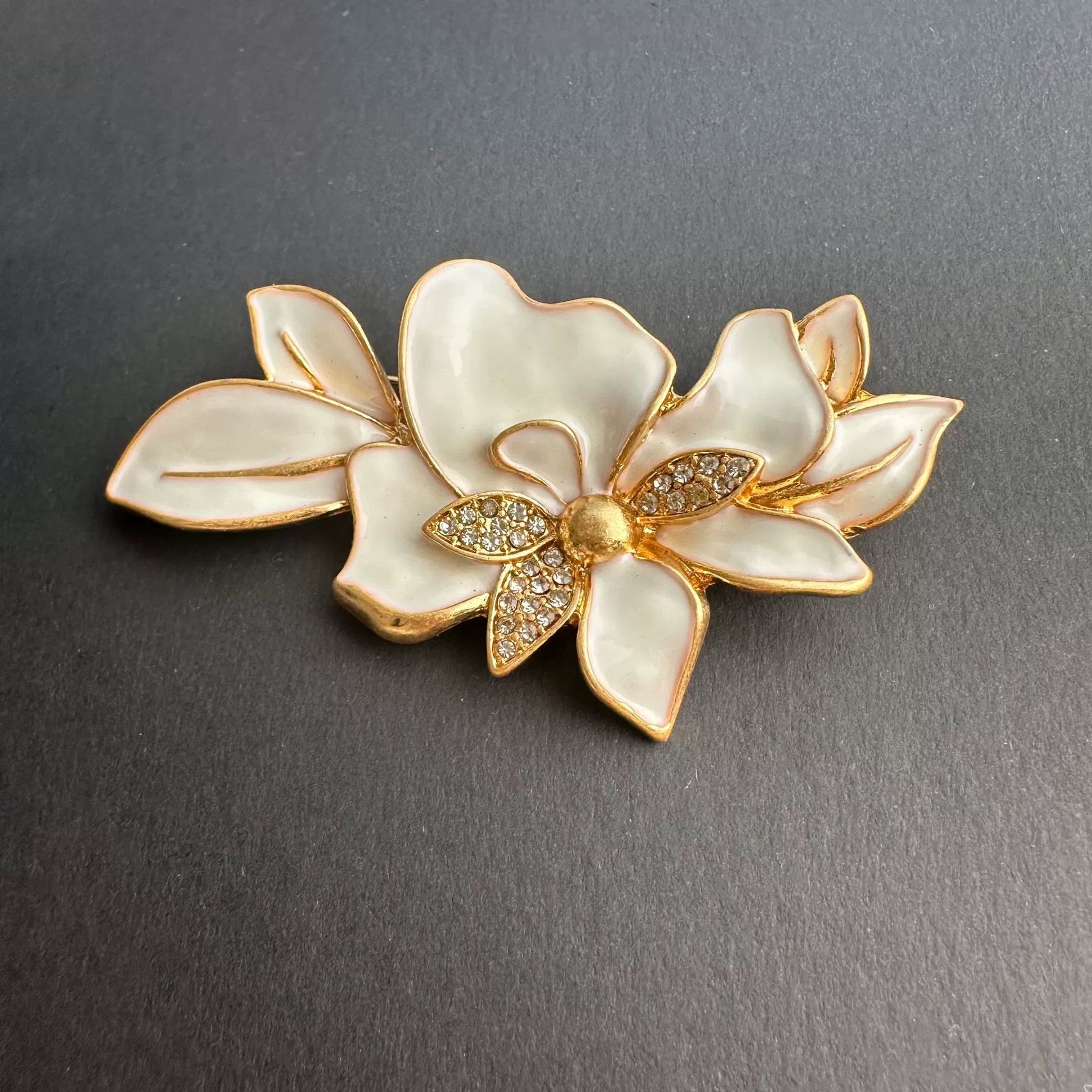 White enamel jasmine flower brooch with gold leaves and rhinestone center