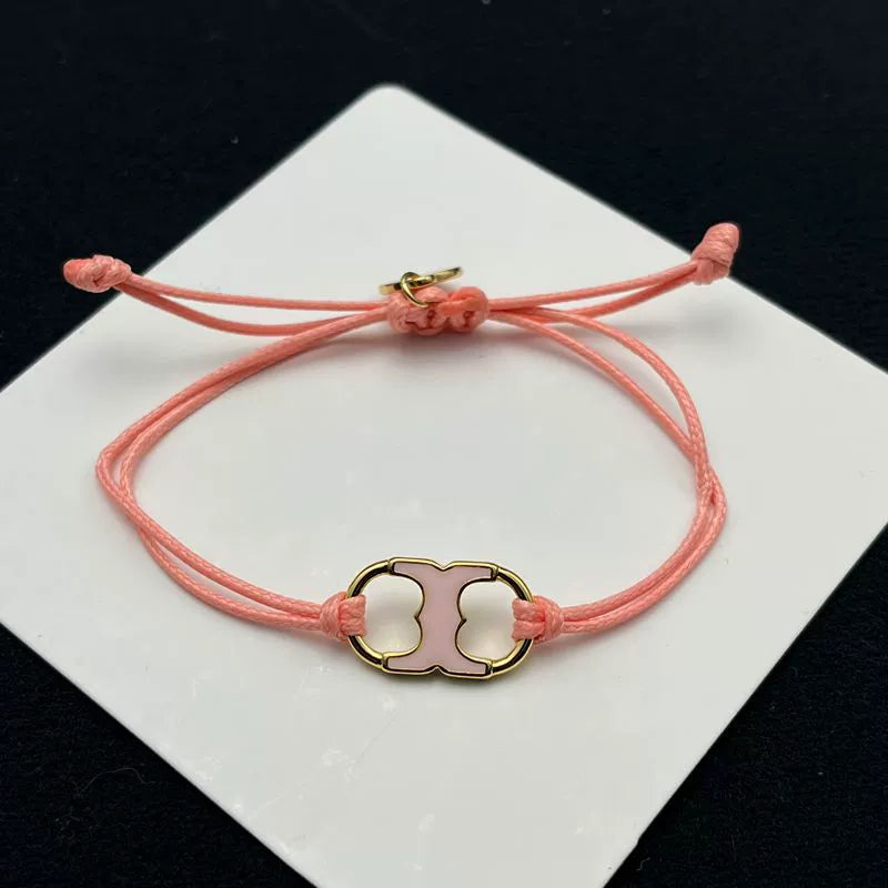 Pulsera con cordón rosa ajustable y dije esmaltado rosa con marco dorado