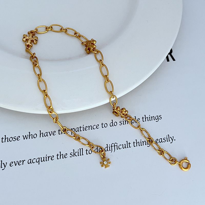 Interlocking logo chain bracelet, gold-tone oval links with clover medallion charms