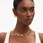 Elegant O-ring floral necklace with small multicolor flower charms, worn at neckline