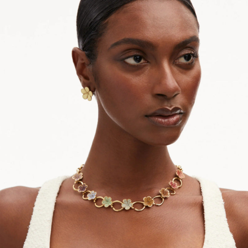 Elegant O-ring floral necklace with small multicolor flower charms, worn at neckline