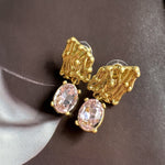 Pink crystal drop earrings with gold-tone textured caps