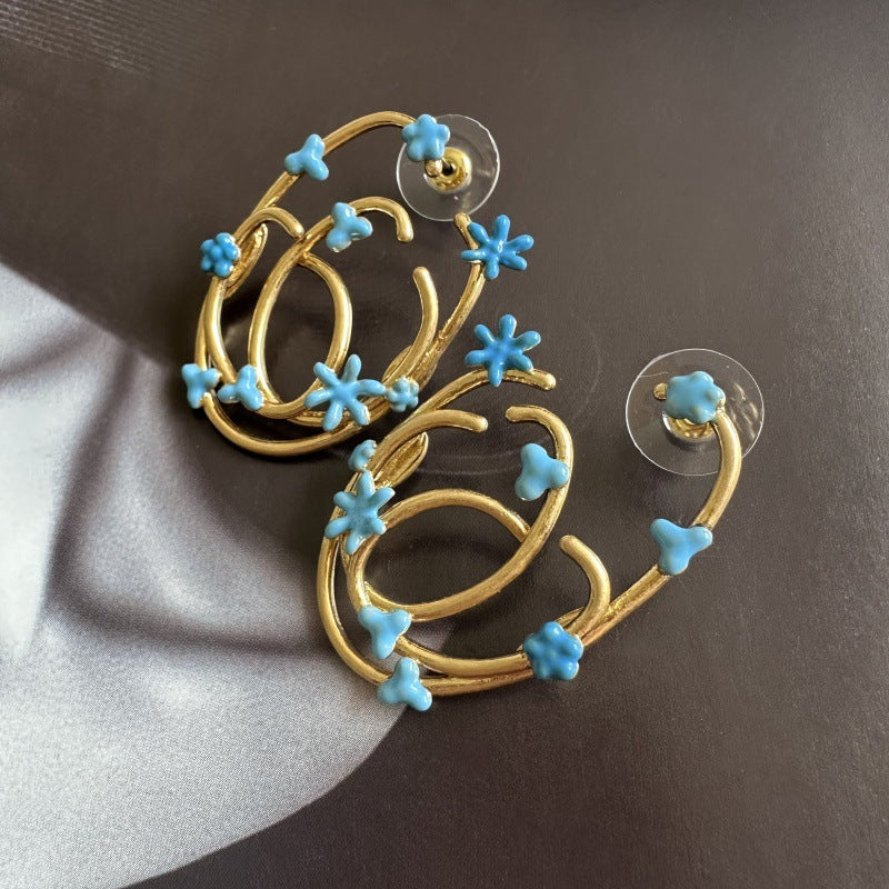 Blue enamel geometric hoop earrings with flower and star charms